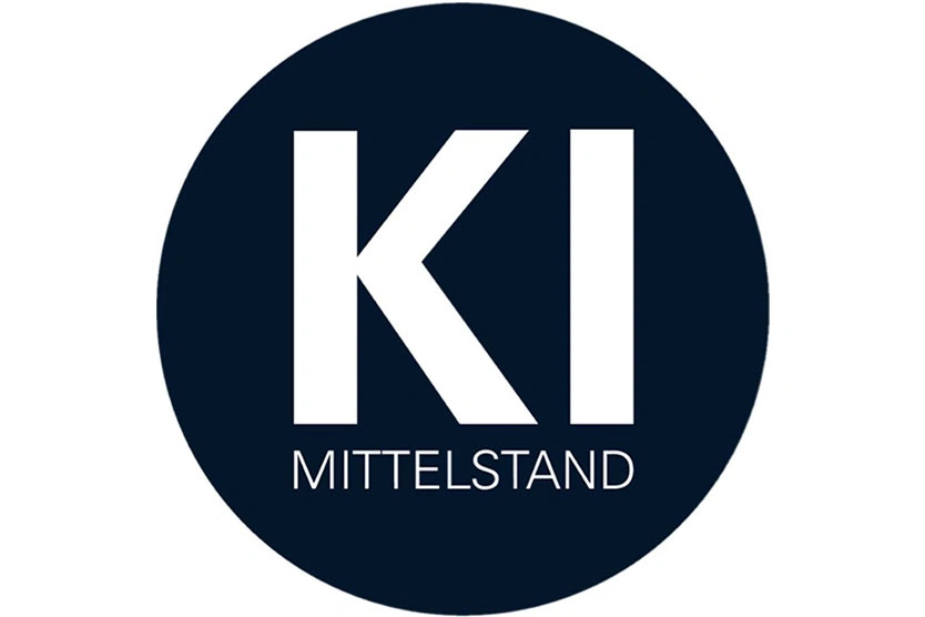White 'KI' and 'MITTELSTAND' text inside a dark blue circular background symbolizing Mittelstand Digital.